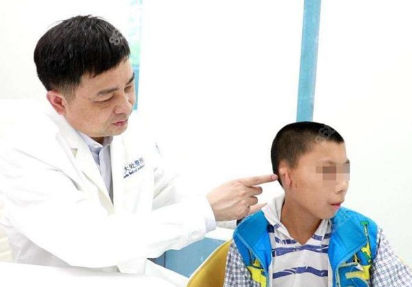 章庆国医生正在给畸形耳孩子面诊